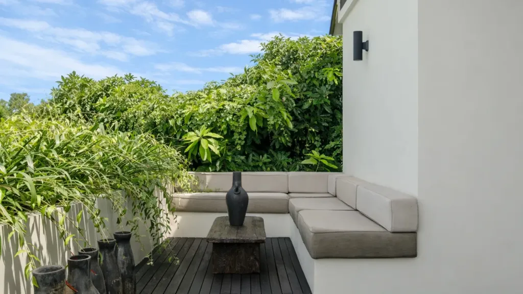 Villa Jaxé, Bingin — terrace, built-in lounge seating on a timber roof terrace behind a green hedge