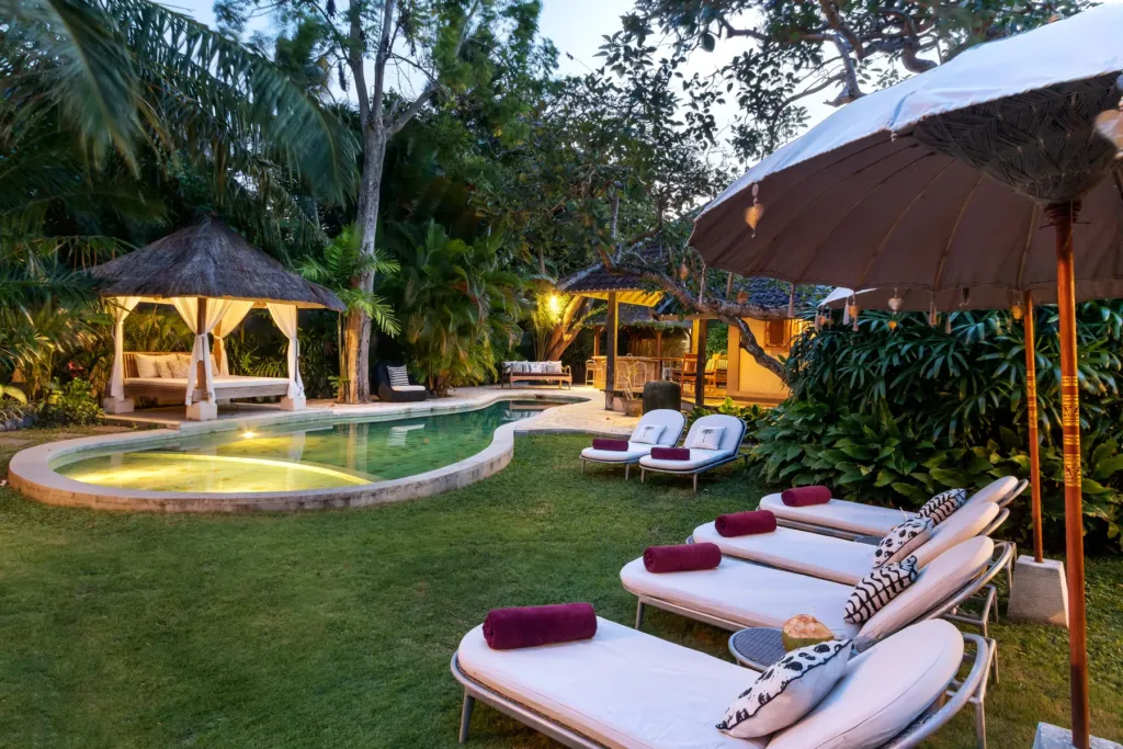 Villa Koyama's pool and garden lit at dusk