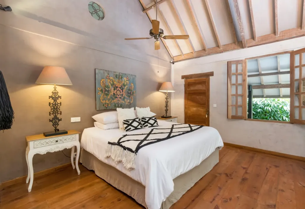 Master bedroom at Villa Koyama with king bed, timber floor and pitched roof