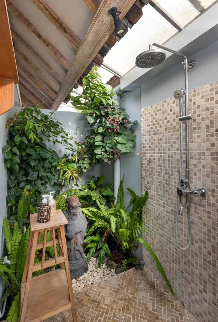 Outdoor shower surrounded by planting in an en-suite at Villa Koyama