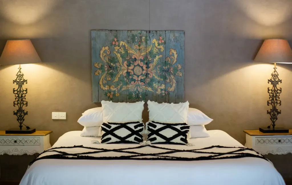Carved and painted headboard detail in a bedroom at Villa Koyama