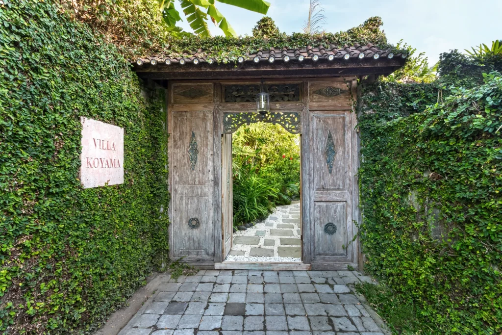 Carved timber entrance gate to Villa Koyama in a quiet Petitenget lane