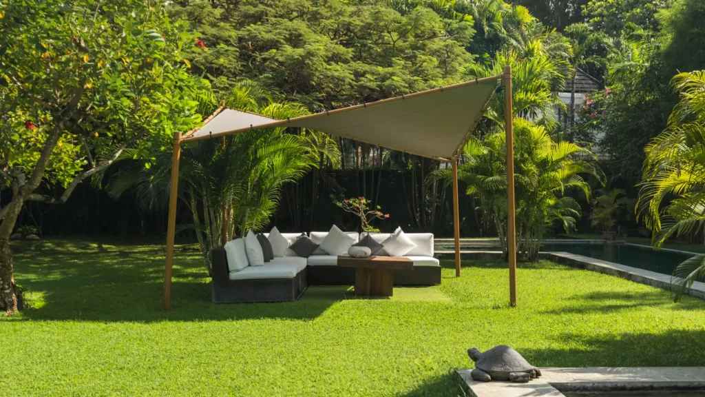 Villa Mogi, Seminyak — garden, shaded garden lounge with cushioned daybeds under a sail canopy at Villa Mogi