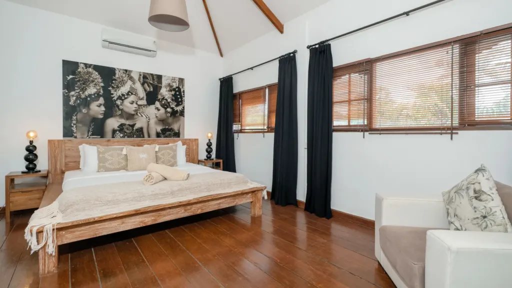 Villa Mogi, Seminyak — bedroom, king bedroom at Villa Mogi with dark timber floors and a sofa