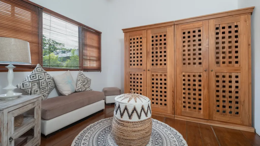 Villa Mogi, Seminyak — bedroom, dressing area at Villa Mogi with a louvred timber wardrobe and sofa
