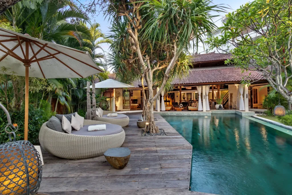 Villa Shantika's pool and lit pavilions after dark