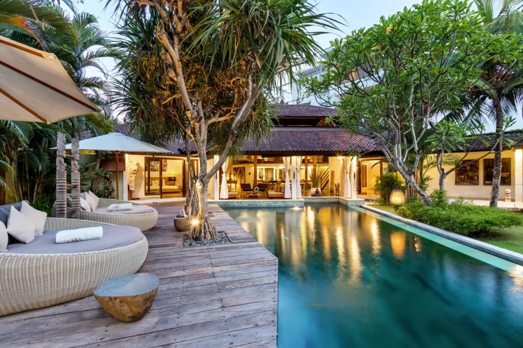 Timber deck and daybed beside the floodlit pool at Villa Shantika