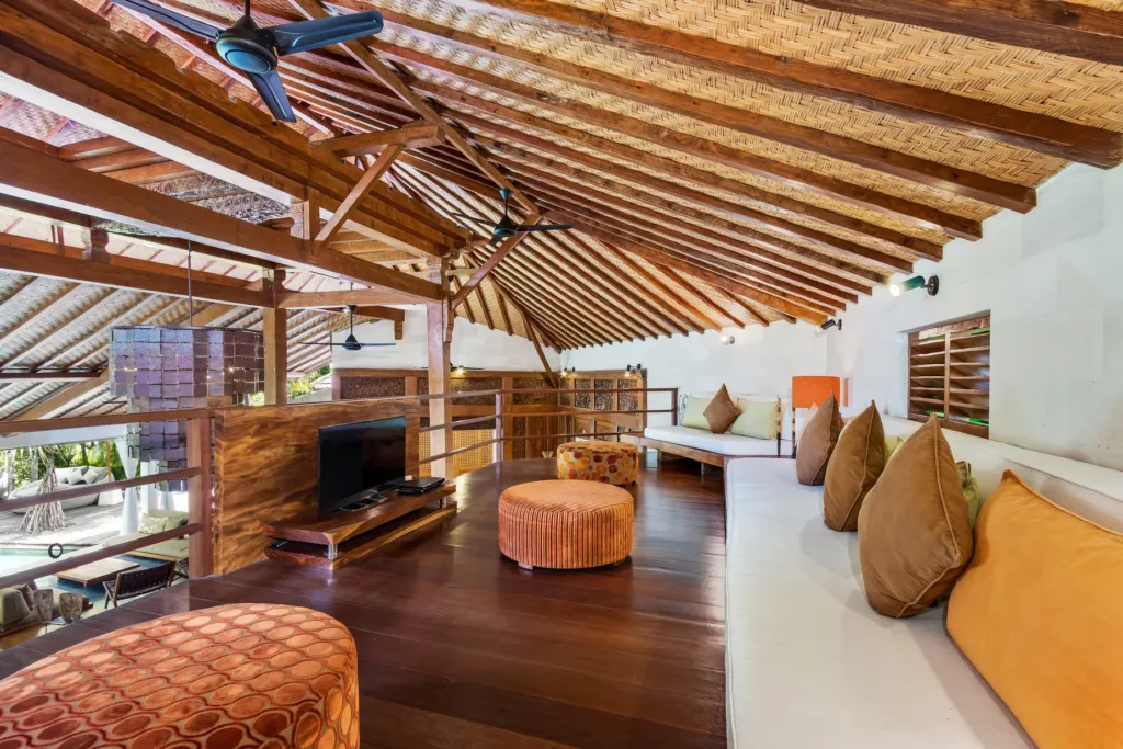 Mezzanine lounge at Villa Shantika with cushions, television and book collection