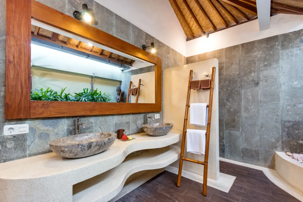 Open-air en-suite at Villa Shantika with twin stone basins and a garden view