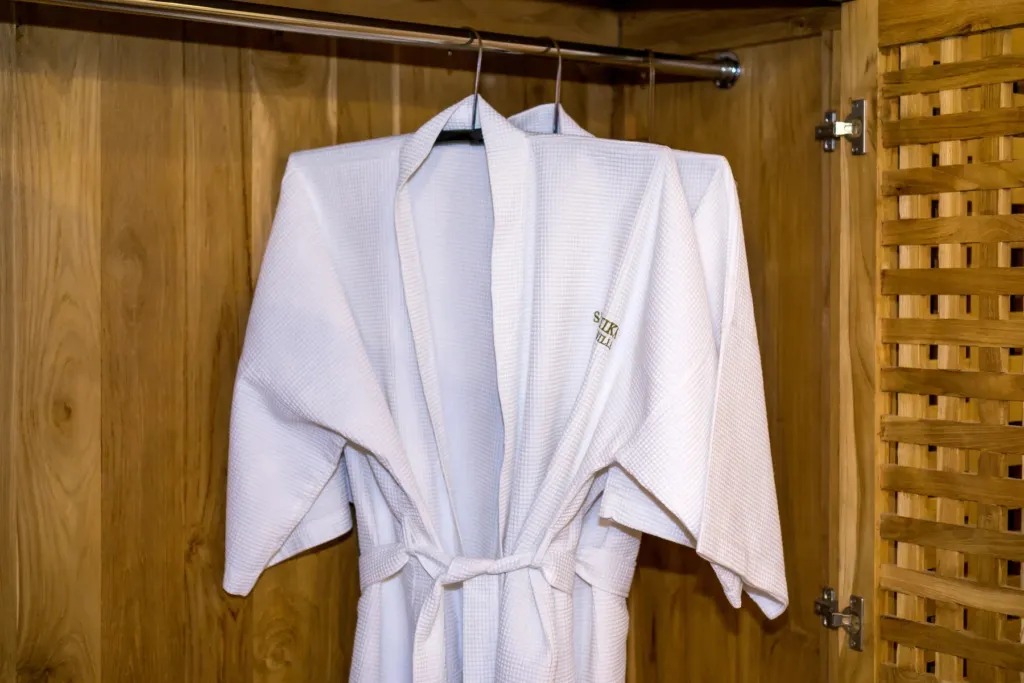 Bathrobe hanging in a timber wardrobe at Villa Shantika