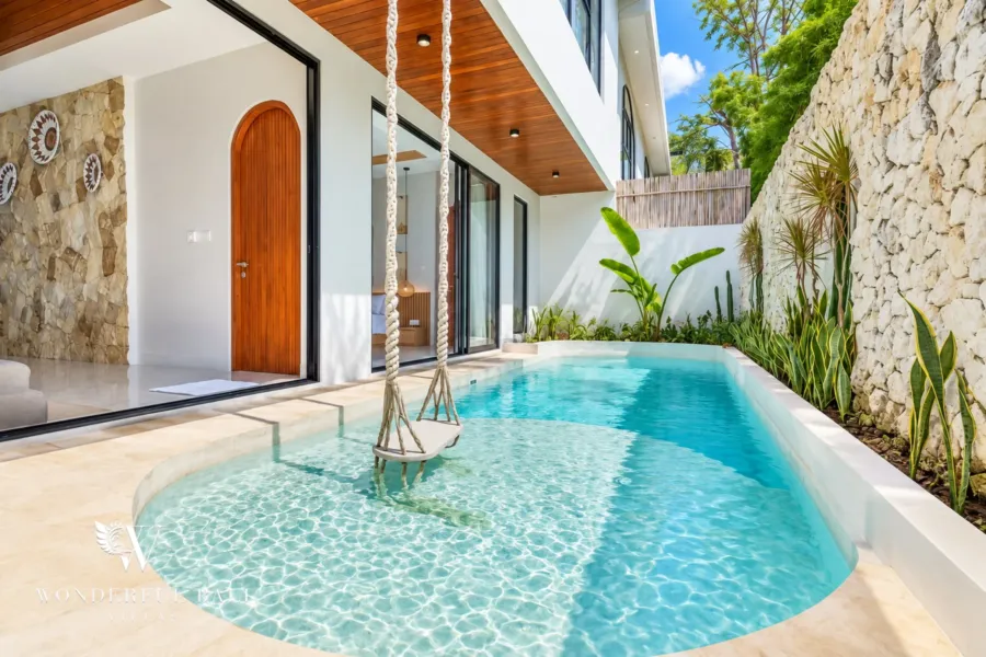 3BR villa for rent in Umalas, Bali — pool, private courtyard pool against a cream stone wall with a hanging chair