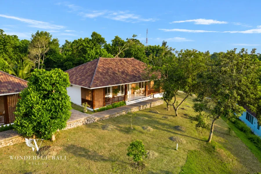 2BR villa for rent in Kaba-Kaba, Bali — exterior, single-storey pavilion with a tiled roof set in lawn and fruit trees