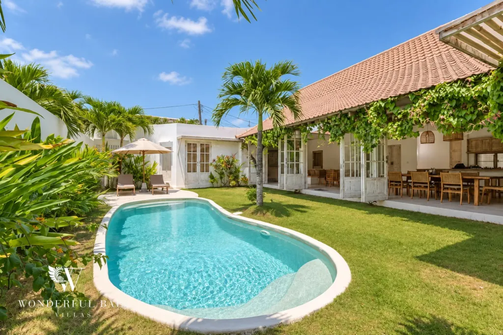 4BR villa for rent in Umalas, Bali — exterior, whitewashed villa with a terracotta roof beside a curved pool
