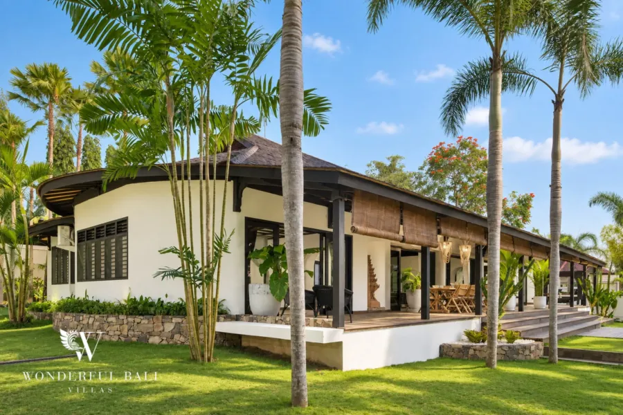5BR villa for rent in Munggu, Bali — exterior, single-storey pavilion with a thatched roof set in lawn and palms