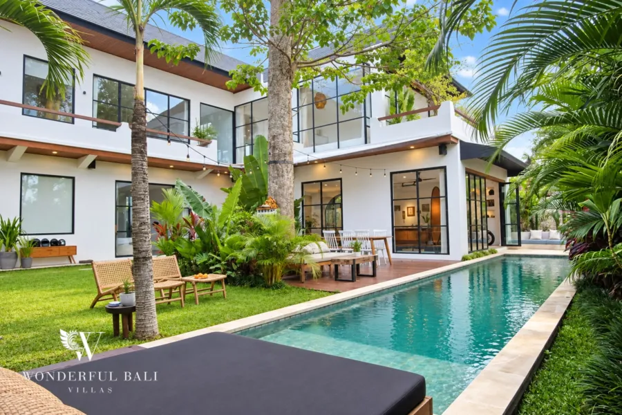 5BR villa for rent in Seseh, Bali — pool, 10 m lap pool and lawn in front of the white two-storey villa
