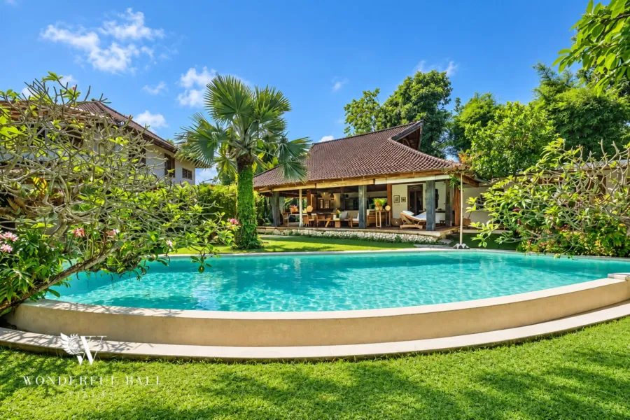 5BR villa for rent in Umalas — pool, curved pool and lawn in front of the teak-roofed living pavilion