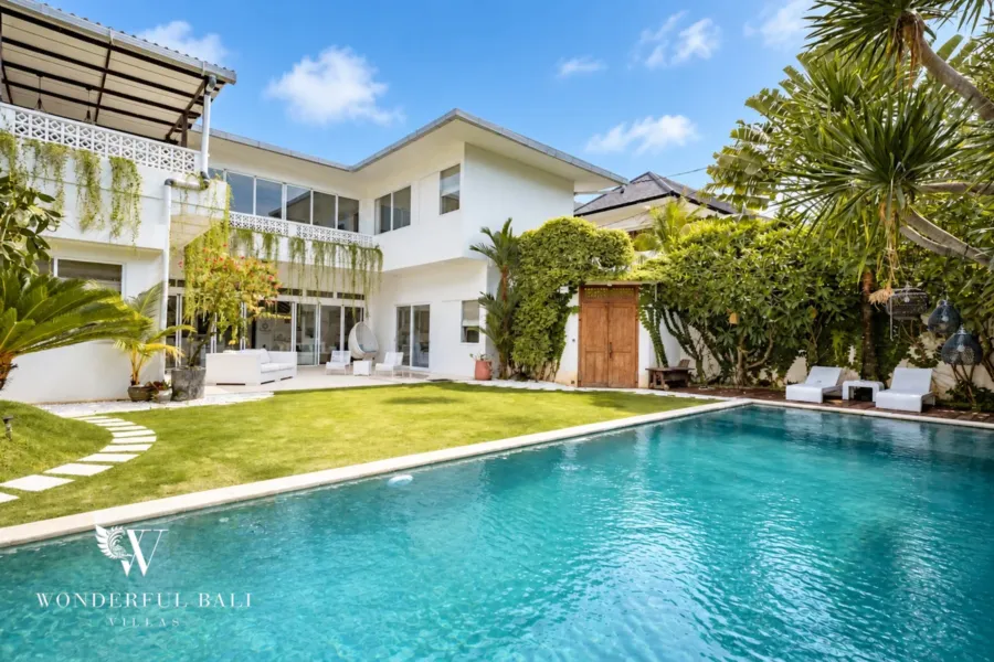 5BR villa for rent in Bumbak, Umalas — pool, large pool and lawn in front of the white two-storey family villa