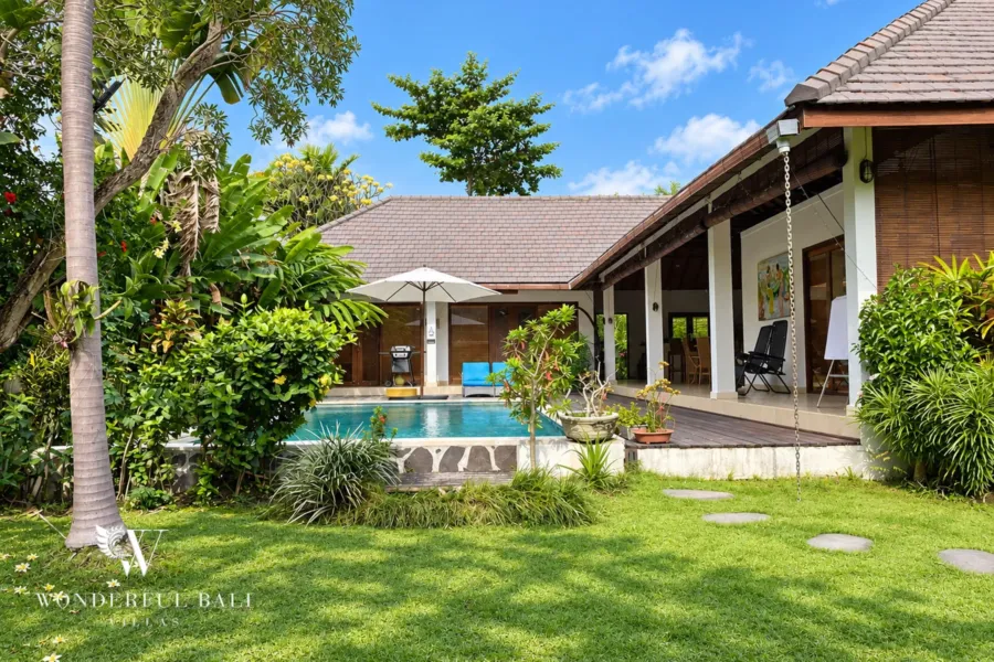 3BR villa for rent in Padonan, Canggu — pool, lawn and overflow pool in front of the tiled-roof living pavilion