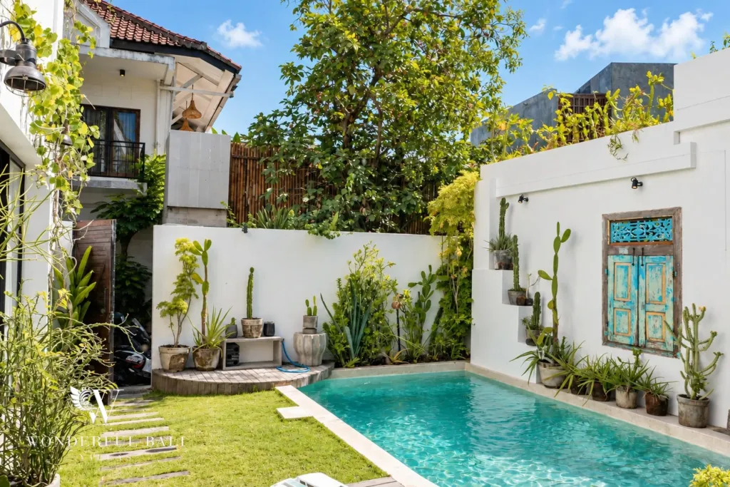 2BR villa for rent in Berawa, Canggu — pool, lawn and stepping stones beside the pool, antique blue Balinese door on the wall