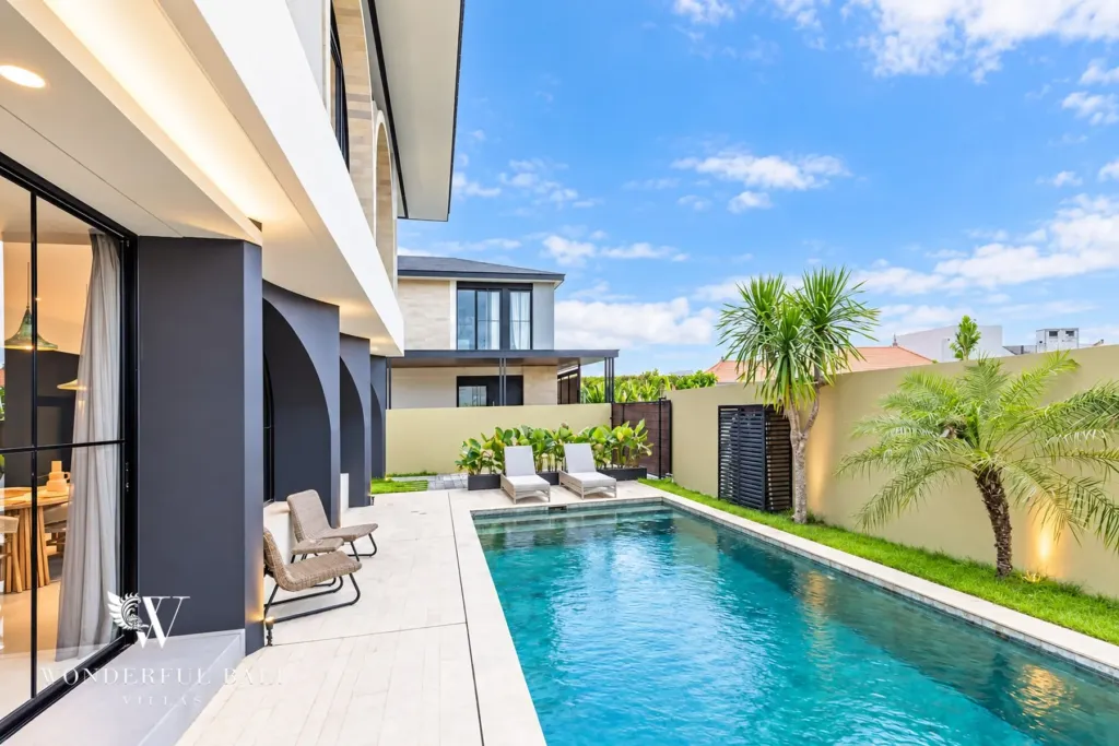 3BR villa for rent in Munggu — pool terrace with sun loungers beside the arched facade