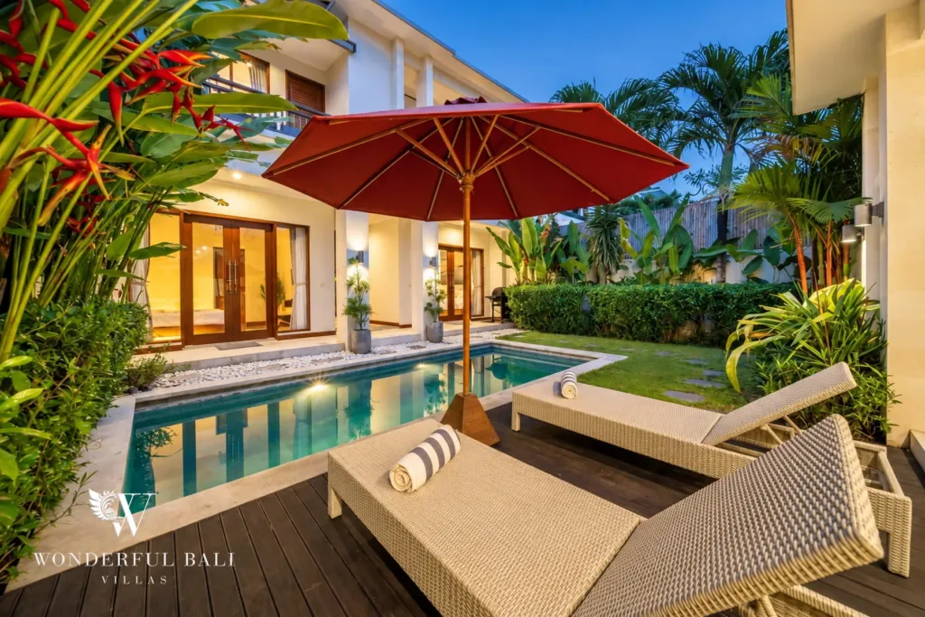 4BR villa for rent in Umalas, Bali — pool, sun loungers and a parasol on the timber deck beside the pool