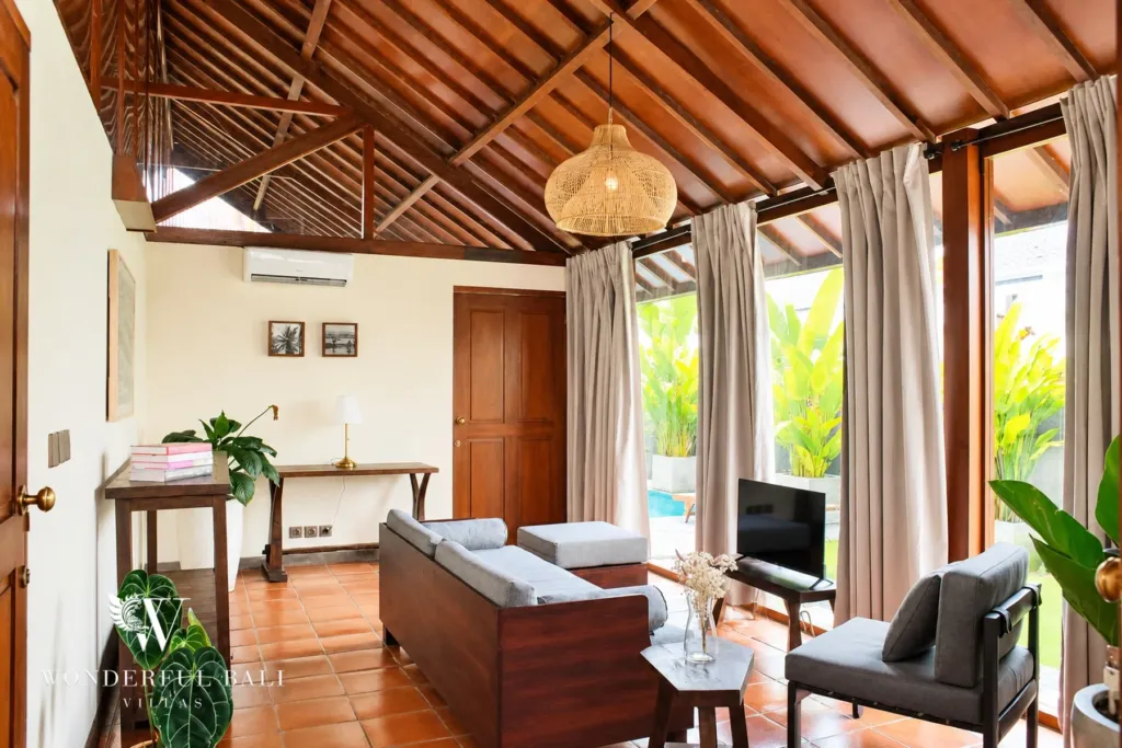 2BR villa for rent in Seseh — living room under a vaulted teak roof with garden views