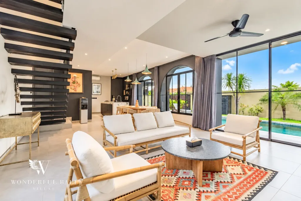 3BR villa for rent in Munggu — living room with floating staircase and glass doors to the pool