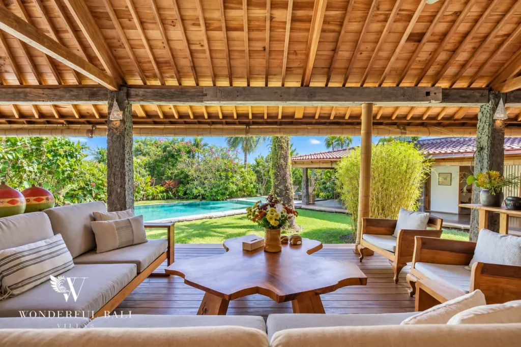 5BR villa for rent in Umalas — living pavilion, teak sofas and a live-edge coffee table looking out to the pool