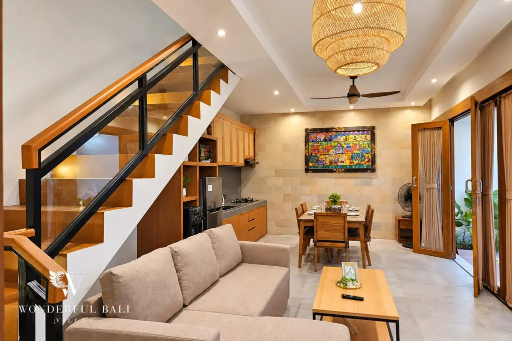 3BR villa for rent in Sanur — open-plan living room with sofa, staircase and kitchen beyond