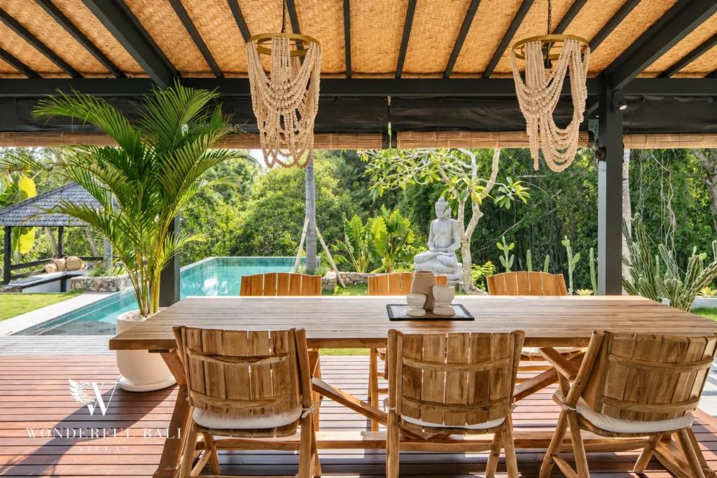 5BR villa for rent in Munggu, Bali — dining area, long timber dining table on the covered terrace above the pool