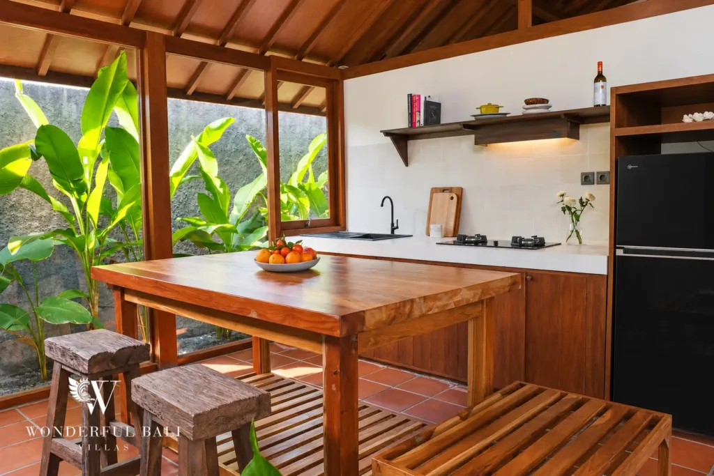 2BR villa for rent in Seseh — kitchen with teak table, stools and garden window
