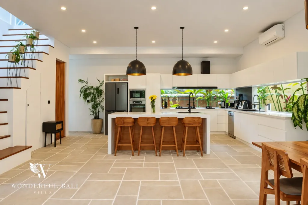 5BR villa for rent in Seseh, Bali — kitchen, white kitchen island with bar stools open to the dining area