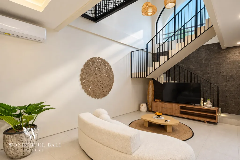 3BR villa for rent in Berawa, Canggu — living room, curved sofa and media wall under the stair