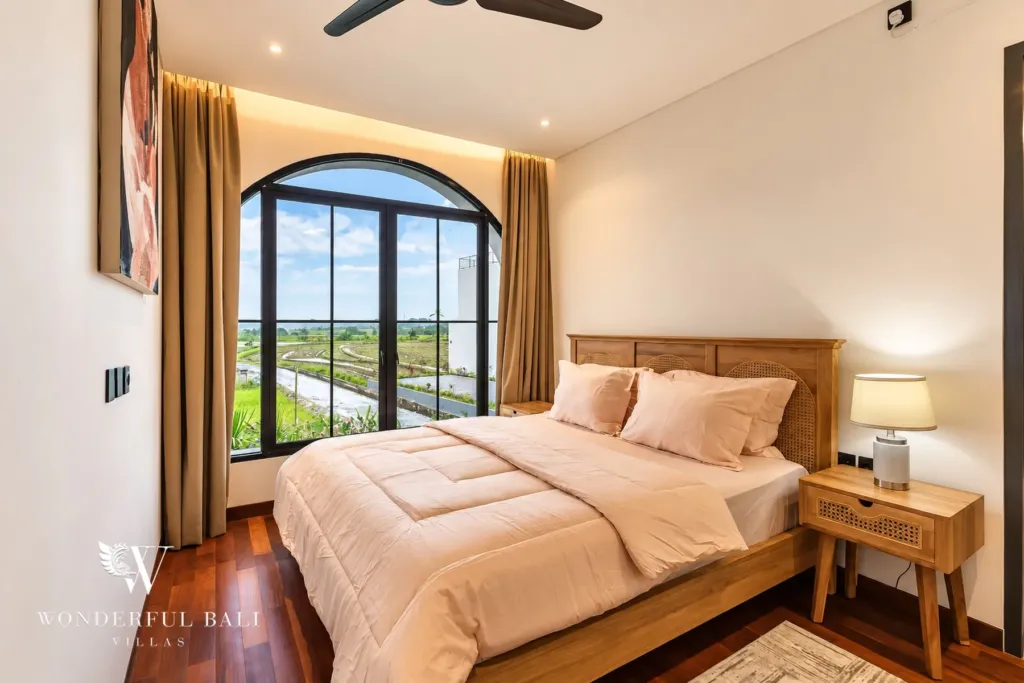 3BR villa for rent in Munggu — main bedroom with arched window over the rice fields