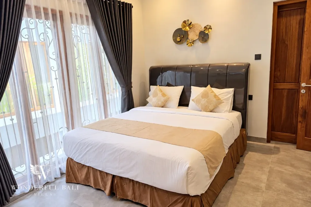 3BR villa for rent in Sanur — main bedroom with leather headboard and French windows