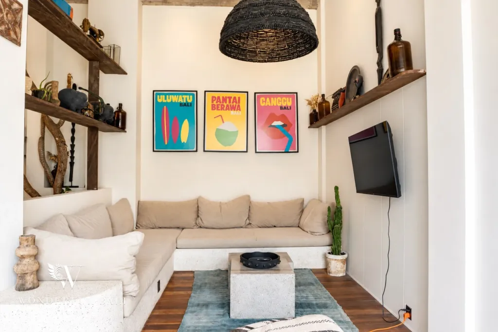 2BR villa for rent in Berawa, Canggu — living room, built-in terrazzo sofa, rattan pendant and a wall-mounted smart TV