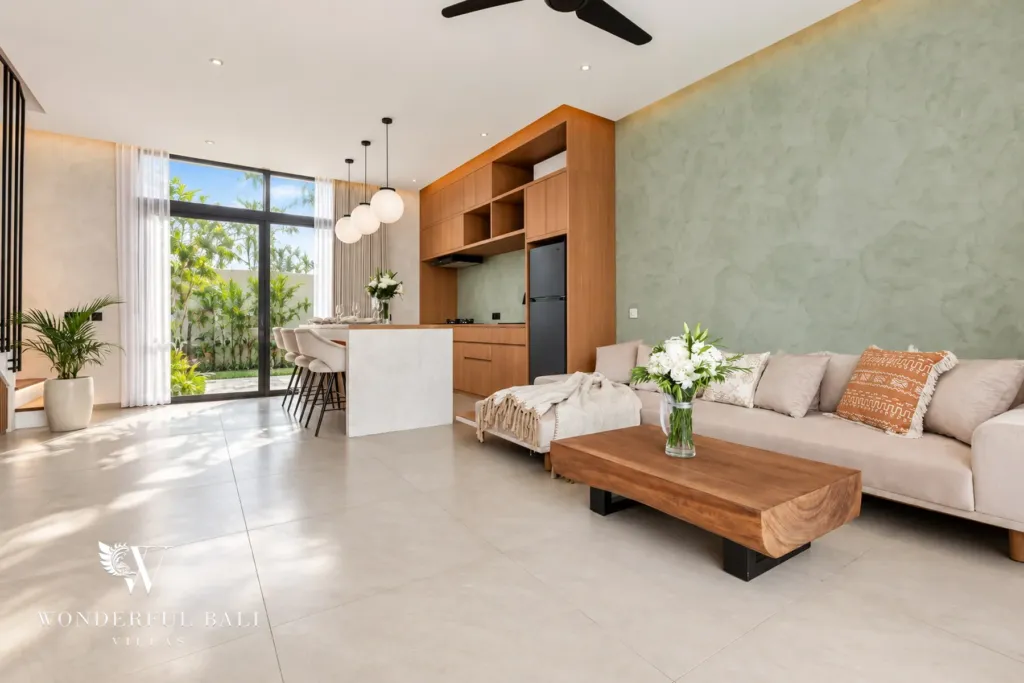 2BR villa for rent in Padonan, Canggu — living room, living room with a sage feature wall and the kitchen behind