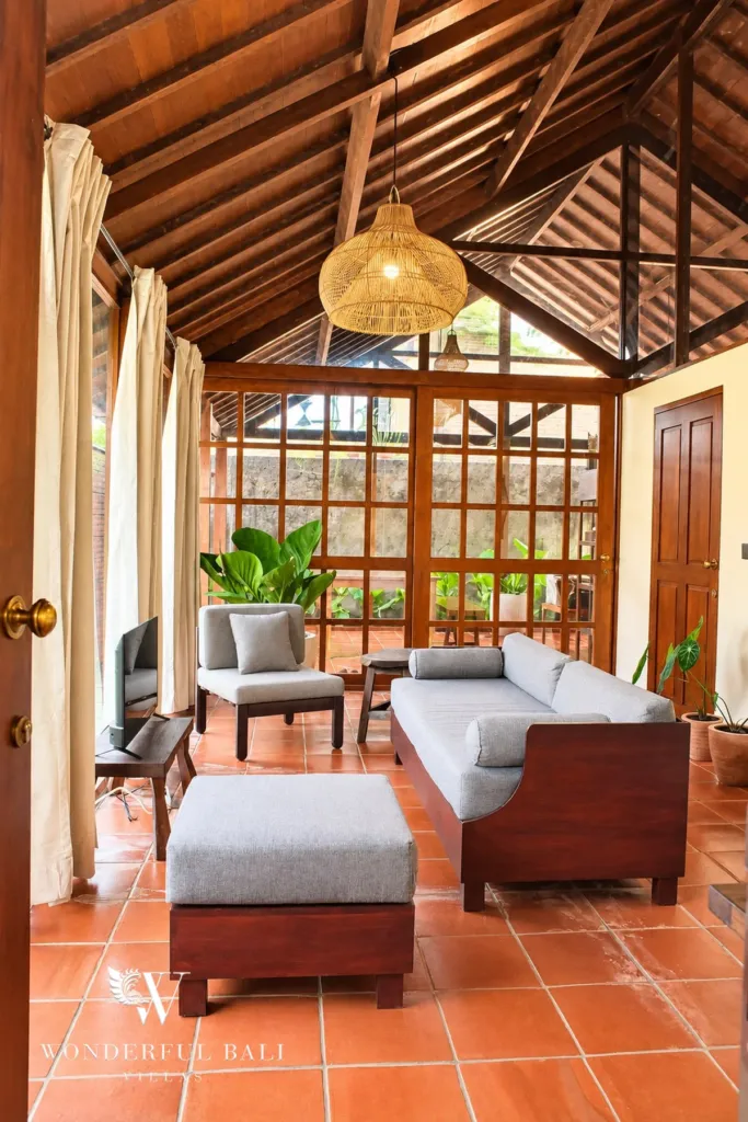 2BR villa for rent in Seseh — living room with timber lattice windows and rattan pendant