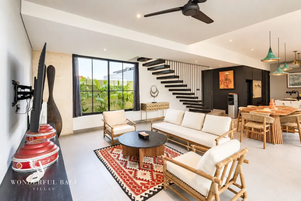 3BR villa for rent in Munggu — open-plan living and dining area with TV and staircase