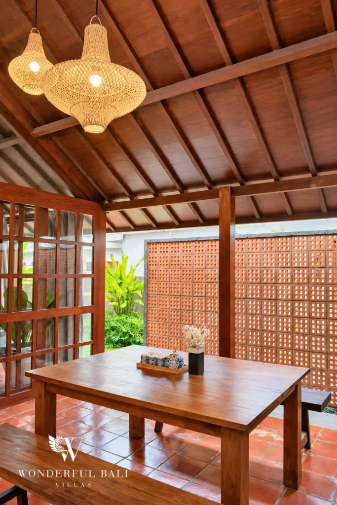2BR villa for rent in Seseh — dining area beside a terracotta breeze-block screen