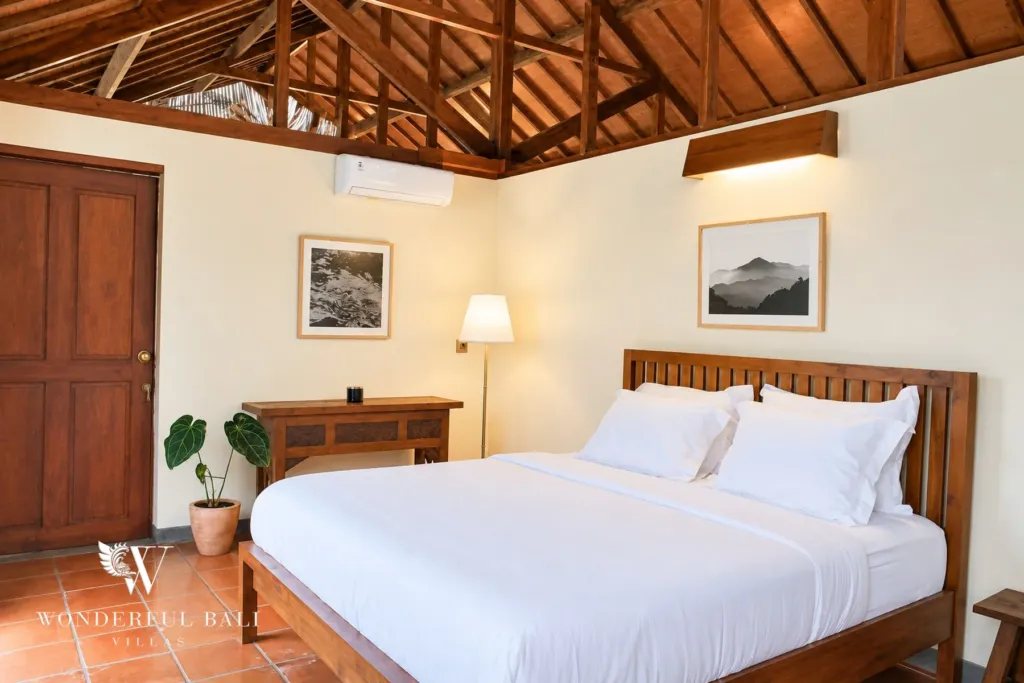 2BR villa for rent in Seseh — second bedroom with teak bed and air conditioning