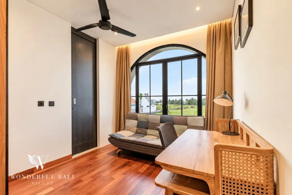 3BR villa for rent in Munggu — workspace with desk, sofa and arched window