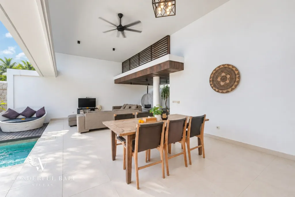3BR villa in Berawa, Canggu, Bali — living room, dining table set alongside the pool courtyard