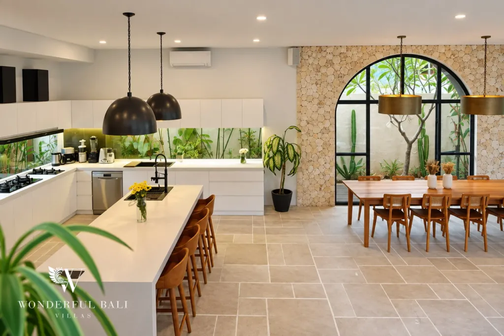 5BR villa for rent in Seseh, Bali — kitchen, wide view of the kitchen with a planted arched window beyond