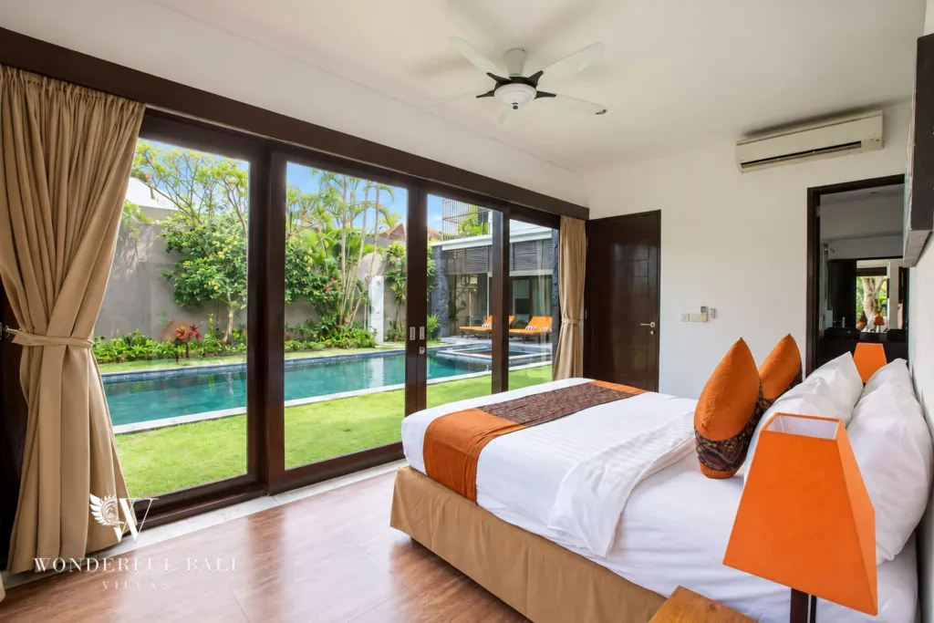 4BR villa for rent in Umalas, Bali — bedroom, ground-floor bedroom with glass doors onto the lawn and pool
