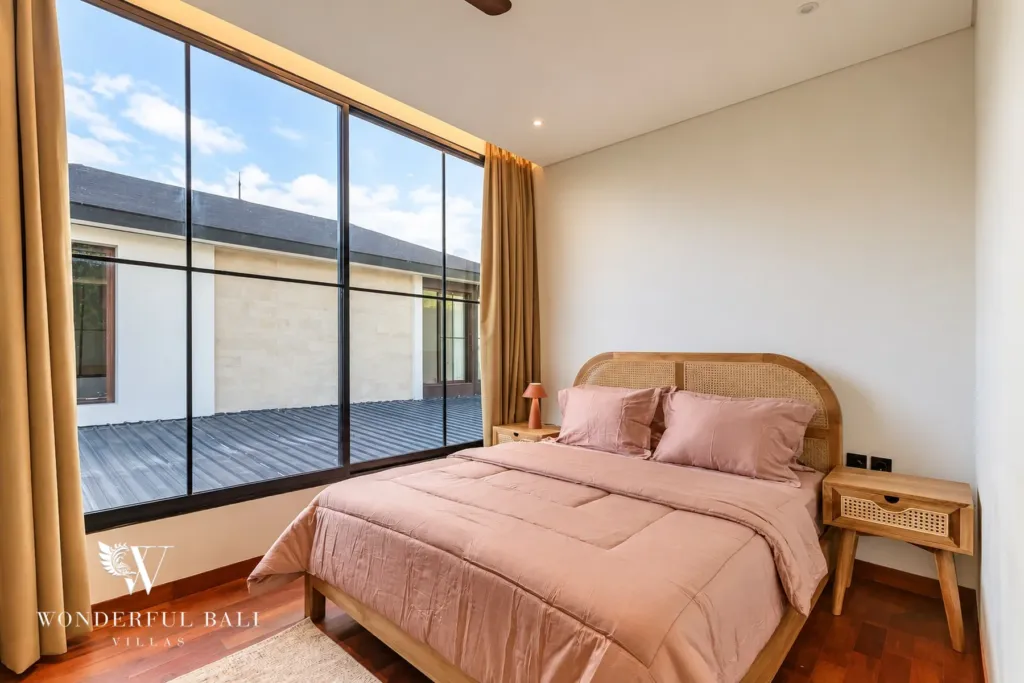 3BR villa for rent in Munggu — second bedroom with rattan headboard and large windows