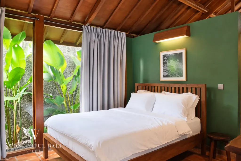 2BR villa for rent in Seseh — second bedroom with green feature wall and garden door