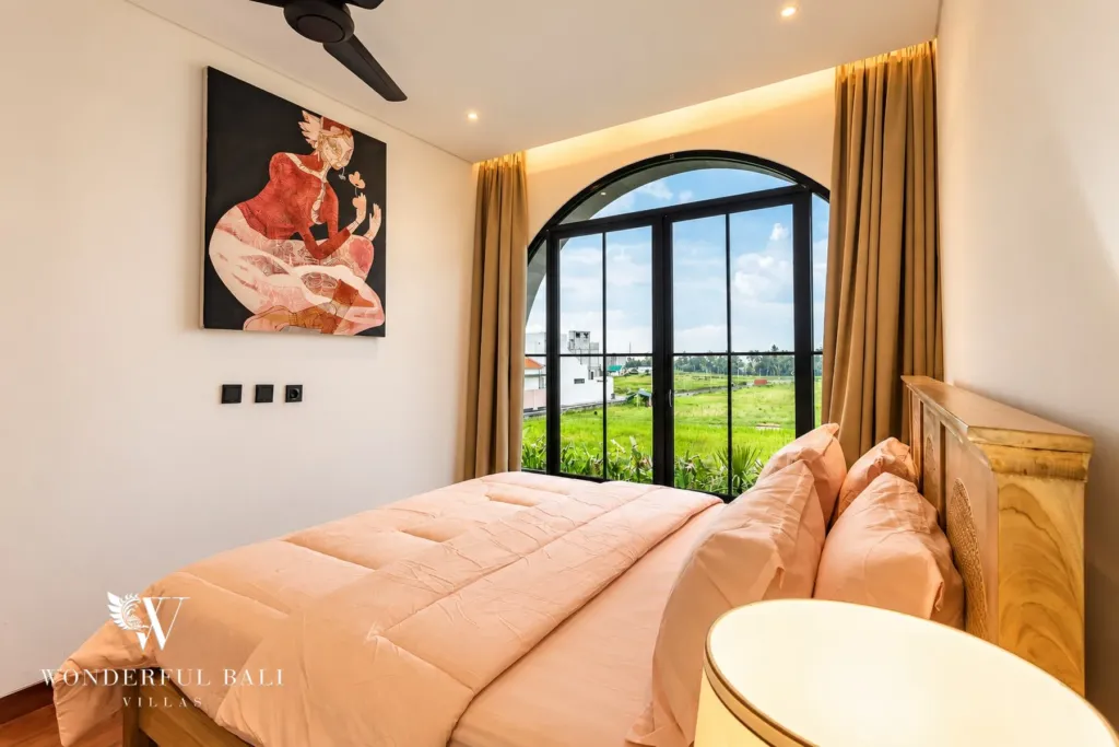 3BR villa for rent in Munggu — bedroom with arched window and rice field view