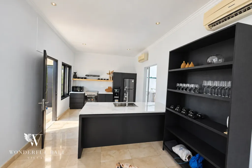 4BR villa for rent in Batu Bolong, Canggu — kitchen, black kitchen joinery with glassware shelving and a marble island