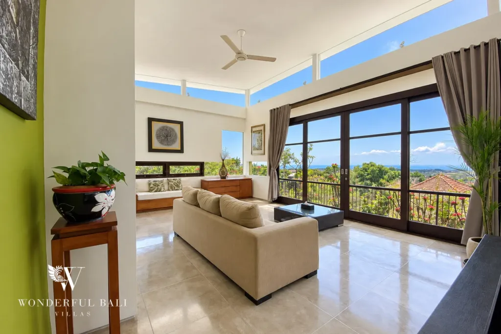 3BR villa for sale in Jimbaran — living room, sofa facing full-height windows with a distant ocean view